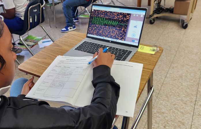  4th grade students in front of his laptop studying sound waves.